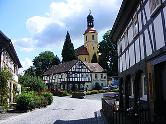 Blick von der Theodor-Haebler-Straße zur Kirche und der Gaststätte Zur Weberstube Blick von der Theodor-Haebler-Straße zur Kirche und der Gaststätte Zur Weberstube